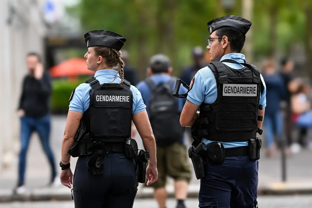 Deux gendarmes de dos en patrouille dans une rue, en tenue de service et gilet tactique marqué Gendarmerie