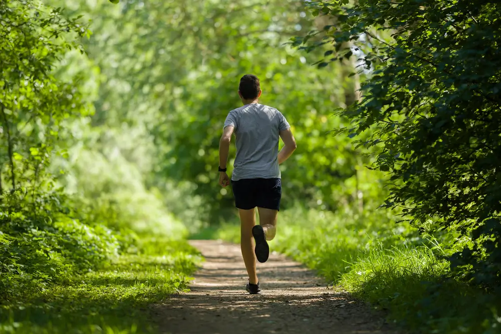 Candidat gendarmerie courant sur sentier d'entraînement militaire lors des épreuves sportives du concours