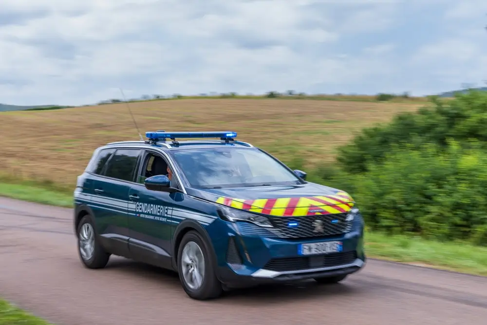 Véhicule de gendarmerie en intervention sur route de campagne avec gyrophares et marquages haute visibilité
