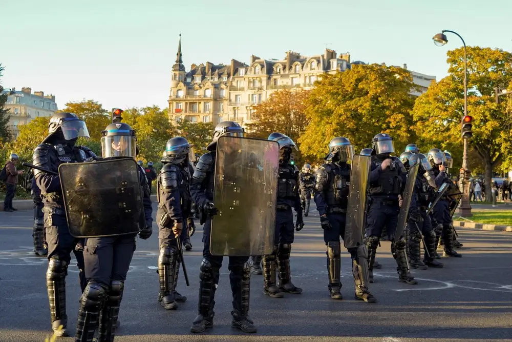 Gendarmes mobiles en tenue anti-émeute avec boucliers et casques lors d'une opération de maintien de l'ordre public