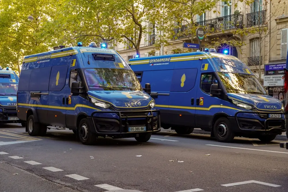 Véhicules de gendarmerie Iveco bleus stationnés dans une rue française lors d'un exercice de formation PMG