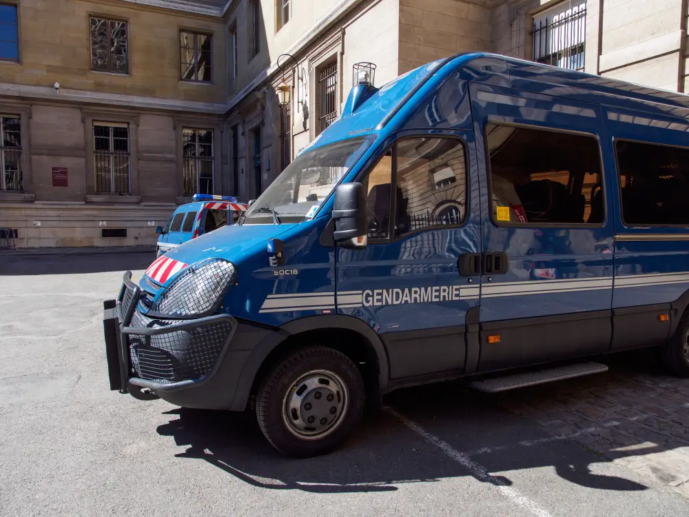 Fourgon bleu de la gendarmerie stationné dans une cour de caserne pour les missions de patrouille du PSIG.