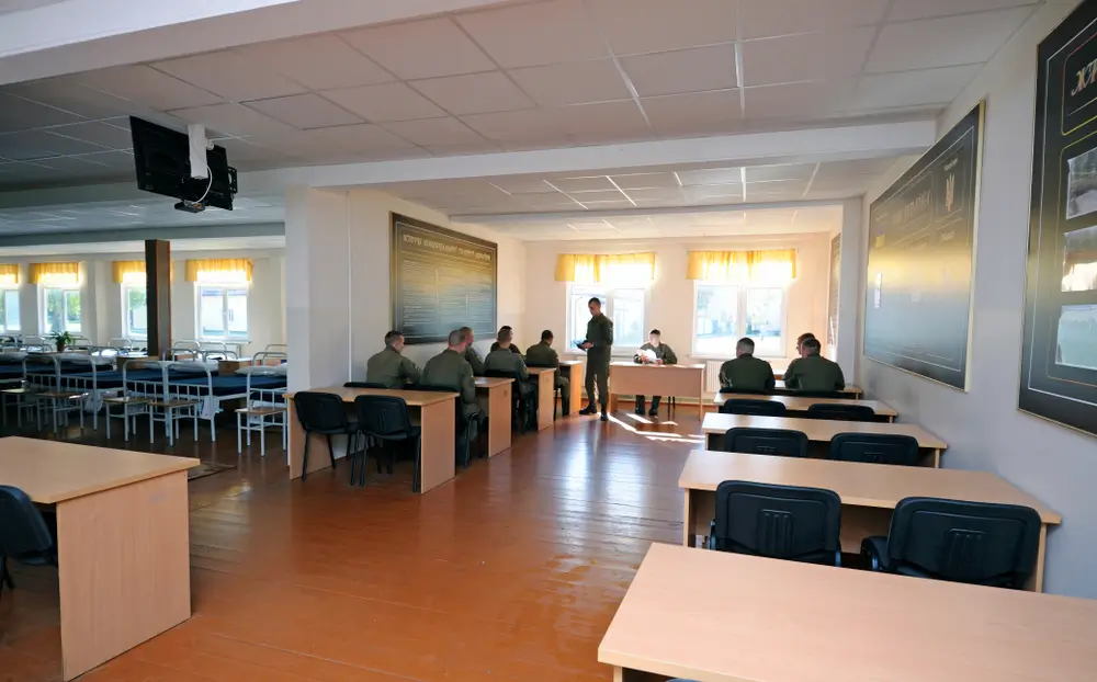 Élèves officiers en uniforme lors d'une séance de formation théorique dans une salle de cours de la gendarmerie.