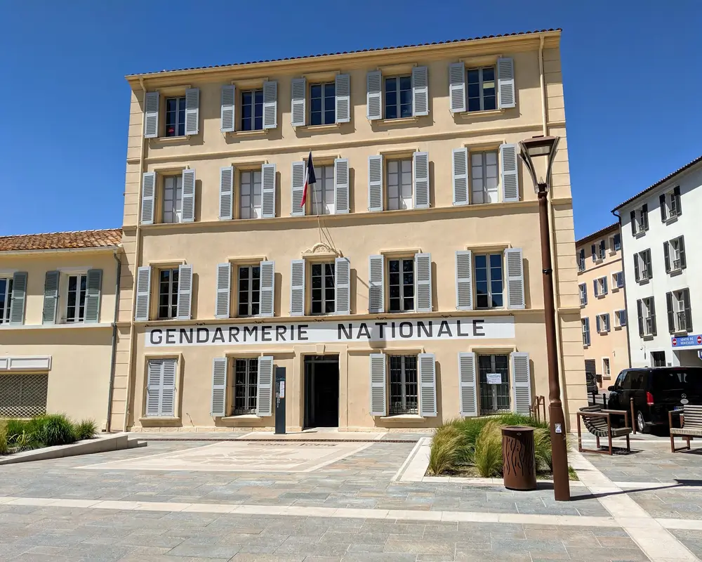Façade d'une caserne de gendarmerie aux volets gris, illustrant les logements de fonction pour militaires.