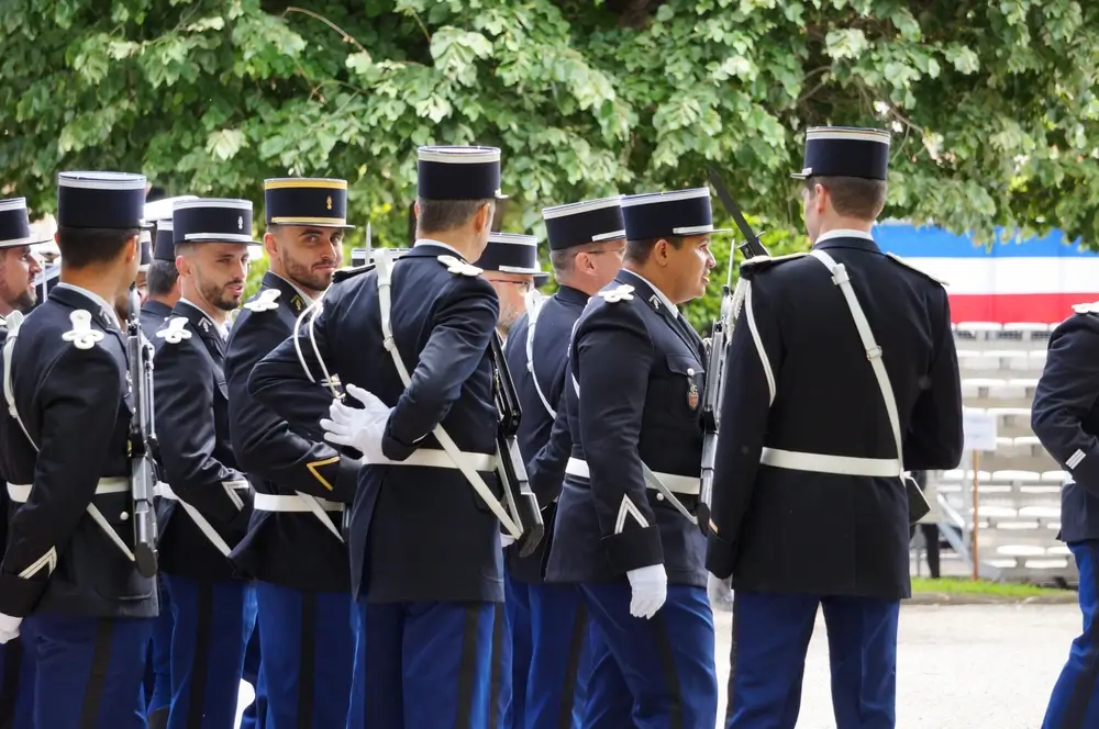 Sous-officiers de gendarmerie en uniforme de cérémonie avec képi, galons et épaulettes blanches.