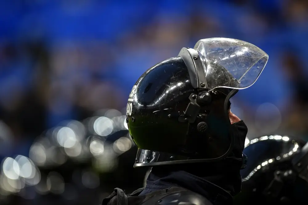 Gros plan d'un gendarme mobile en tenue de maintien de l'ordre portant son casque d'intervention avec visière levée.