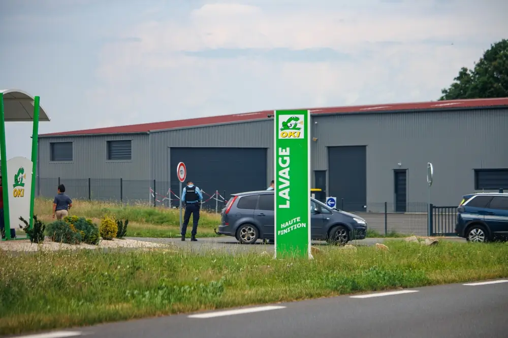 Un gendarme en uniforme procède au contrôle routier d'un véhicule sur le bas-côté de la route.