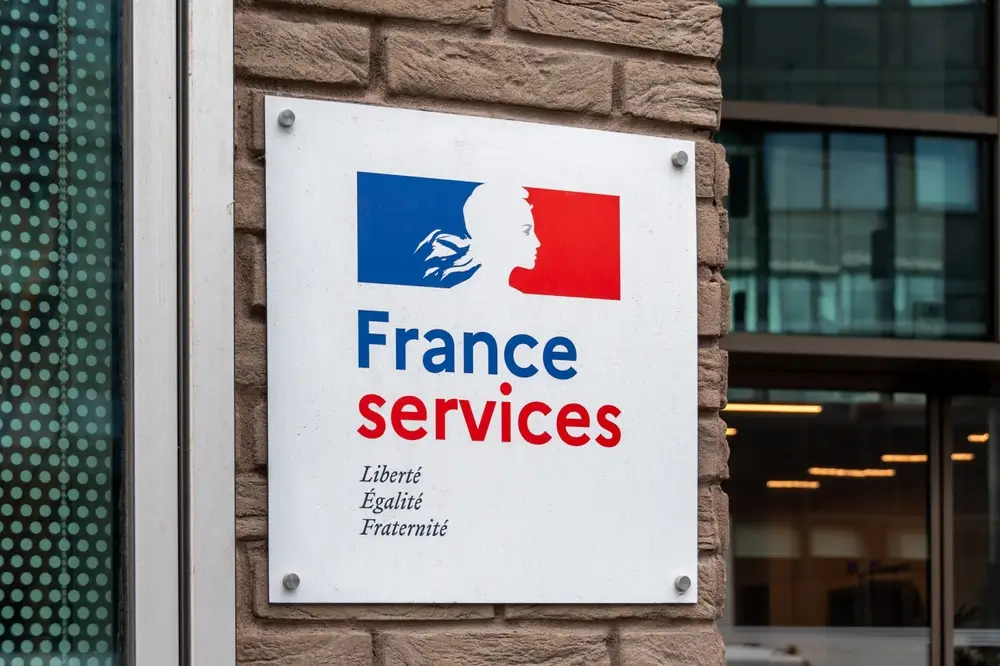 Plaque France Services sur la façade d'un bâtiment administratif officiel pour les démarches de service public.