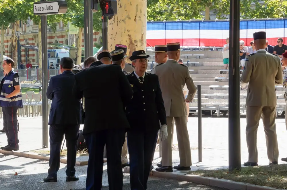 Officiers de gendarmerie en uniforme militaire et képi lors d'une cérémonie officielle devant un Palais de Justice.