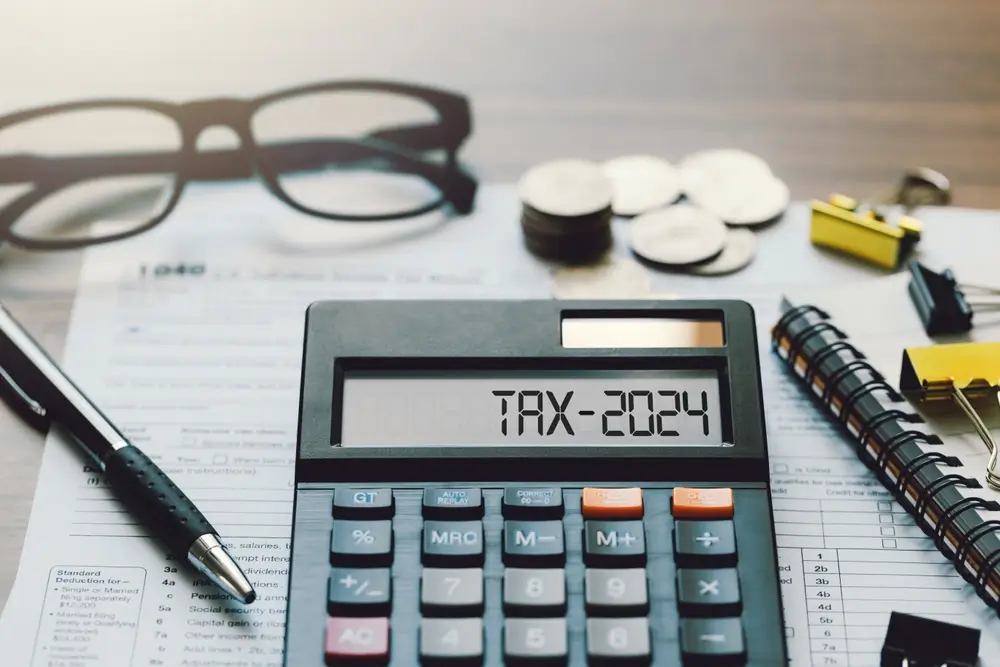 Calculatrice TAX-2024 sur des documents fiscaux, illustrant la déclaration d'impôts sur la solde du gendarme réserviste.