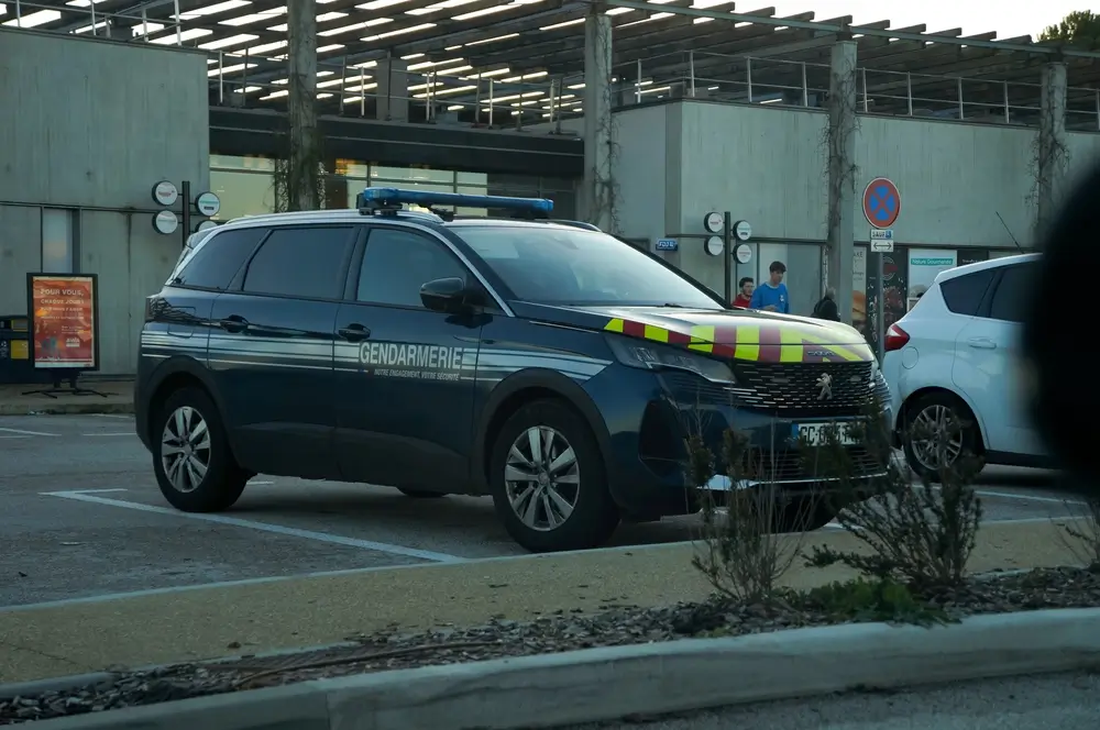Voiture de gendarmerie stationnée en caserne, illustrant l'obligation de disponibilité liée au logement de service.