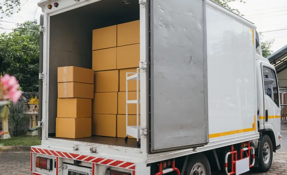 Cartons de déménagement empilés dans un camion ouvert lors du changement de logement d'un gendarme et de sa famille.
