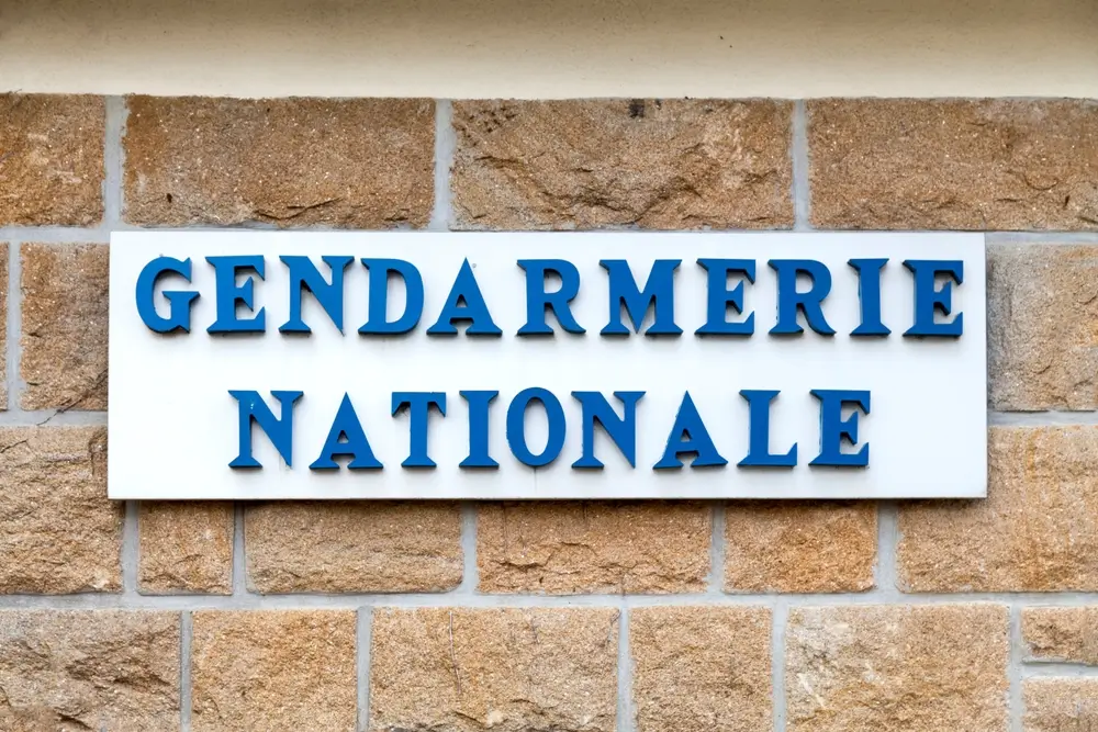 Panneau Gendarmerie Nationale sur pierre, illustrant la grille salariale et la progression de carrière militaire.