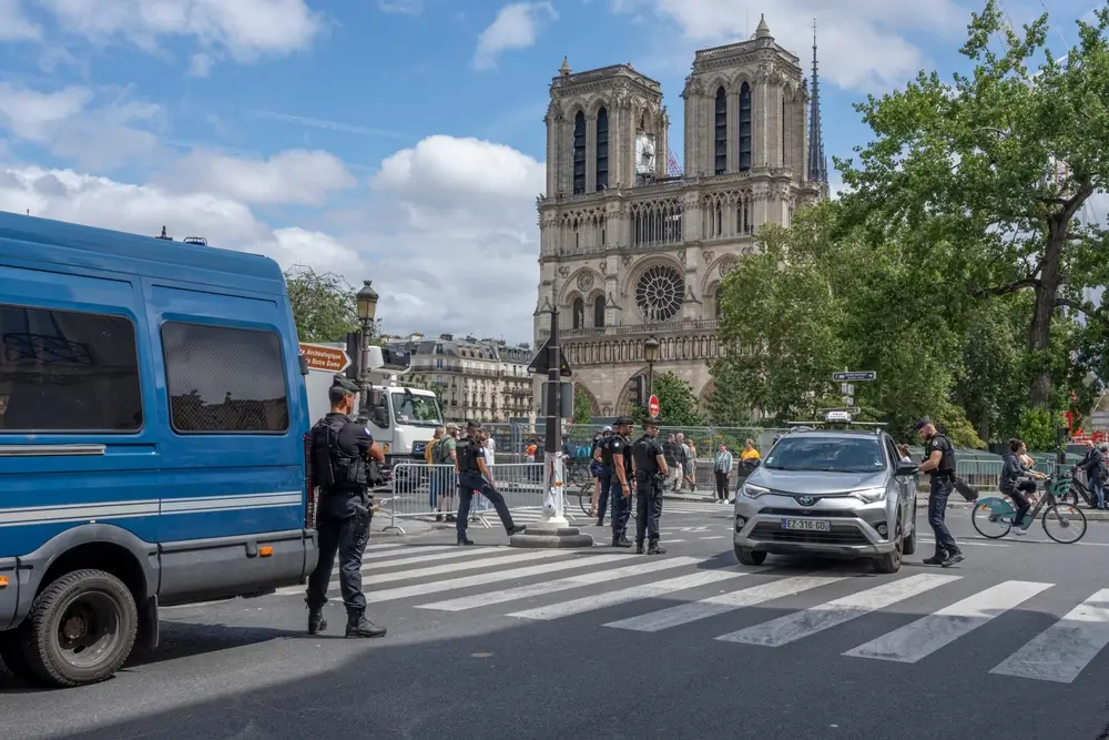 Gendarmes en uniforme et véhicule de patrouille en mission de surveillance devant Notre-Dame de Paris.