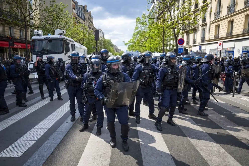 Policiers et gendarmes mobiles en ligne lors d'une opération de maintien de l'ordre avec casques et boucliers.