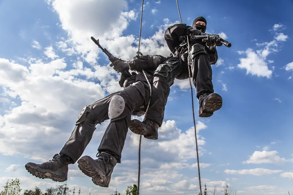 Opérateurs des forces spéciales armés descendant en rappel lors d'un exercice d'assaut d'aéronef.