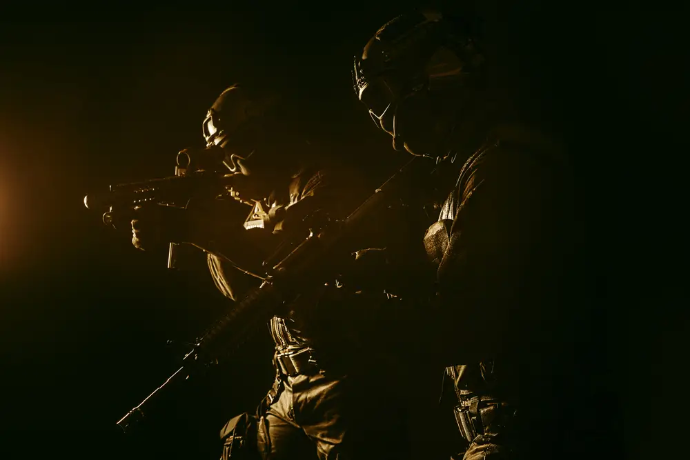 Deux gendarmes du PSIG en équipement tactique avec casques et fusils d'assaut lors d'une patrouille de nuit.
