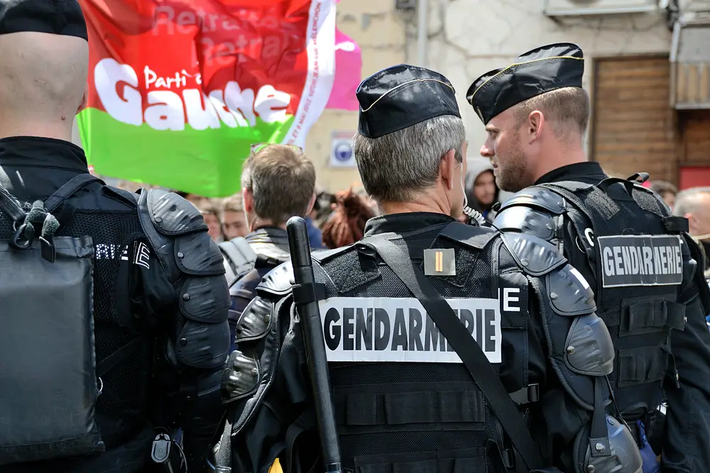 Groupe de gendarmes en tenue d'intervention partageant un moment de camaraderie et de cohésion professionnelle.